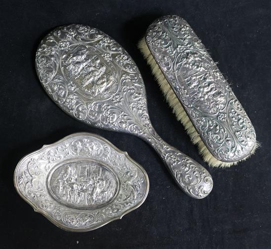 A Dutch silver-backed hand mirror (835) and brush, embossed with tavern scene and scrolling foliage and a similar pin tray